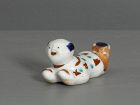 An Arita porcelain whistle in the form of a reclining Chinese boy
