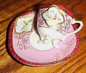 Fancy vintage demitasse cup and saucer with three legs or feet