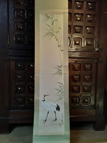 Antique asian scroll of a standing crane with bamboo